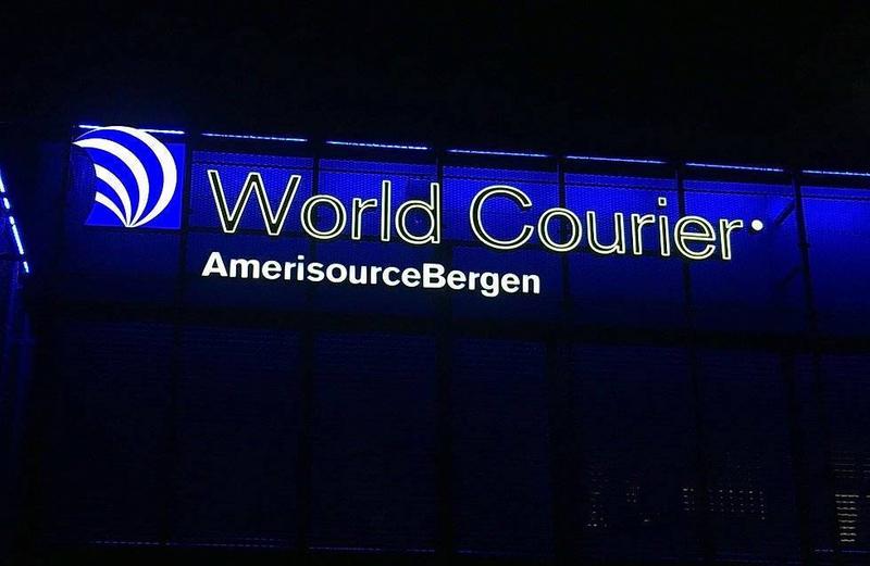 Amerisourcebergen mit Logozeichen als Leuchtkasten durch Folientechnik.
Die Typo von World Courier sind Marquee Buchstaben in Profil 5. Die Foliengestaltung als Outline-Design, hat ein Drahtgeflecht dahinter, in der sich das Licht dahinter spiegelt und eine blaue Kontur wirftt.