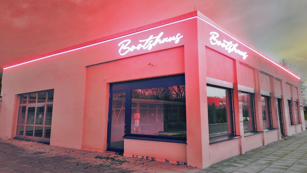 Das Gebäude bekommt durch sein Logo im Neon-Design einen Vintage-Charakter an der Aussenfassade. Eine umlaufende Konturbeleuchtung mit der gleichen Lichtfarbe wie vom Sign-Logo, gibt den Bootshaus ein Gesamtbild. Das LED-Farblicht in rot beleuchtet das gesamte Gebäude. Durch die Architekturbeleuchtung im Neon-Design wirkt das Bootshaus schon vom weiten wie ein Blickfang.
