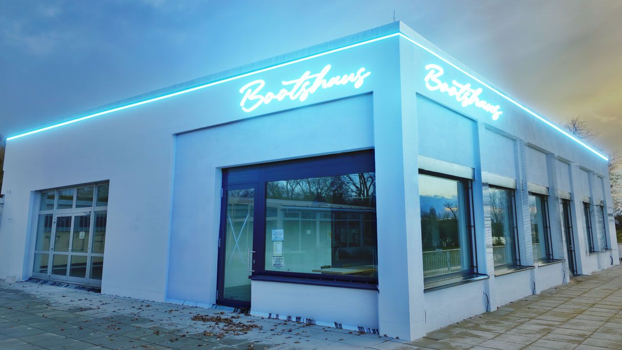 Das Gebäude bekommt durch sein Logo im Neon-Design einen Vintage-Charakter an der Aussenfassade. Eine umlaufende Konturbeleuchtung mit der gleichen Lichtfarbe wie vom Sign-Logo, gibt den Bootshaus ein Gesamtbild. Das LED-Farblicht in rot beleuchtet das gesamte Gebäude. Durch die Architekturbeleuchtung im Neon-Design wirkt das Bootshaus schon vom weiten wie ein Blickfang.