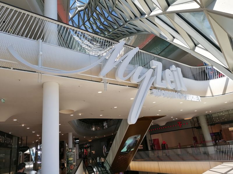 Das Atrium des MyZeil zeigt die Komplexität unserer Arbeit. MyZeil Innenraum Beschilderung und Werbetechnik, Montage im mehrstöckigen Atrium. Im Eingang zwischen den Stockwerken ist die große, abgehängte MyZeil-Profilschrift instaliert.