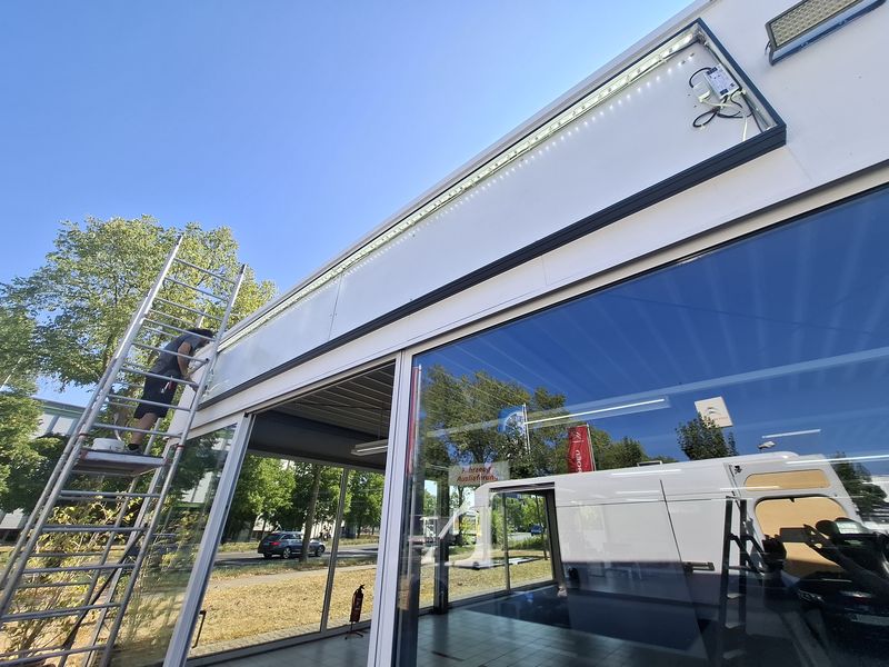 Unser Techniker bei der Montage und LED-Verkabelung eines Leuchtkastens an der Fassade des Autohauses Höptner.