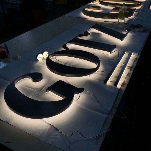 LED-hinterleuchtete Profilbuchstaben mit warmweißer Rückrbeleuchtung in der Fertigung für hochwertige Leuchtwerbung im Innen- und Aussenbereich. Rückseitig beleuchtete 3D-Buchstaben mit LED-Technik auf Montagetisch. Profilbuchstaben für professionelle Werbeanlagen die individuell gefertigt wurden.