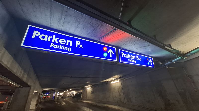 Intelligente Parkleitsysteme durch moderne Leuchtkästen. Effiziente Orientierung und Echtzeit-Information im Parkhaus. Hochwertigen LED-Leuchtkästen für Parkhäuser kombinieren klassische Wegweiser mit intelligenter Technik. Wie im Anwendungsbeispiel zu sehen, dienen diese Lichtwerbeelemente nicht nur der statischen Beschilderung, sondern fungieren als Parkleitsystem mit Ampelsystem. Die Integration von roten und grünen LED-Signalen ermöglicht es Autofahrern, bereits aus der Distanz die Parkplatzverfügbarkeit zu sehen.