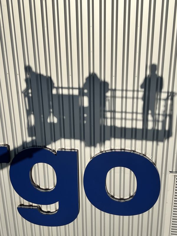 Lufthansa Cargo in frisch umlackierten blauen Buchstabenfronten des „Cargo“-Schriftzugs. Gut zu erkennen sind die von uns installierten Vogelschutz-Spikes (Taubenabwehr) oberhalb der Buchstaben, die die neue Anlage dauerhaft vor Verschmutzung schützen. Der Schattenwurf der Monteure im Hubsteiger oberhalb der Profilbuchstaben.
