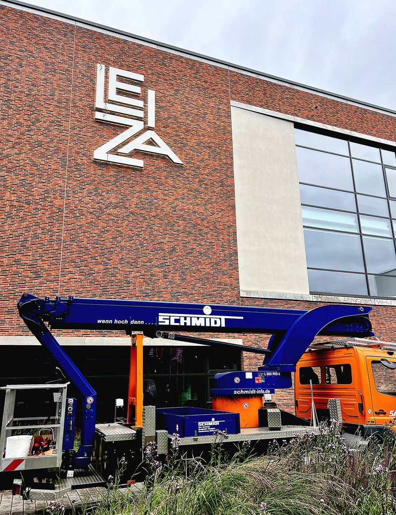 Außenwerbung Leiza Montage einer großformatigen Werbeanlage mit Aluminium-Profilbuchstaben an einer Gebäudefassade mittels Hubarbeitsbühne. Professionelle Installation einer LED-Fassadenwerbung an einer Klinkerwand. Eine langlebige und hochwertige Werbeanlage mit beeindruckender Fernwirkung.