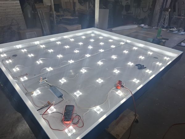 Blick in den geöffneten LED-Leuchtkasten während der Fertigung des Parkhausschilds für die Höbig-Grundstückverwaltung. Zahlreiche LED-Module sind gleichmäßig auf der Innenfläche angeordnet und elektrisch miteinander verbunden. Vor der Montage wird die Beleuchtung auf Funktion und gleichmäßige Ausleuchtung geprüft.