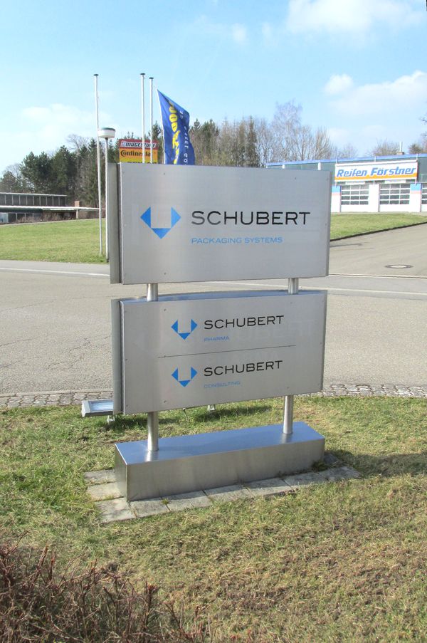 Edelstahl-Firmenbeschilderung und Logo Edelstahl-Firmenpylon mit großem Schubert Packaging Systems Logo sowie separater Beschilderung für Schubert Pharma und Schubert Consulting. Professionelle Unternehmensbeschilderung.